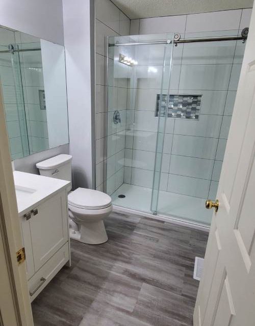 White vanity beside glass shower
