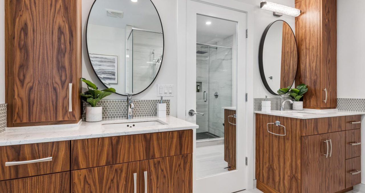 Twin walnut vanities with round mirrors